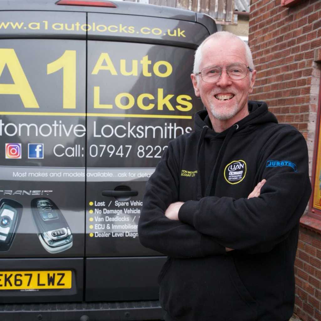 Male staff member smiling next to A1 Autolocks van